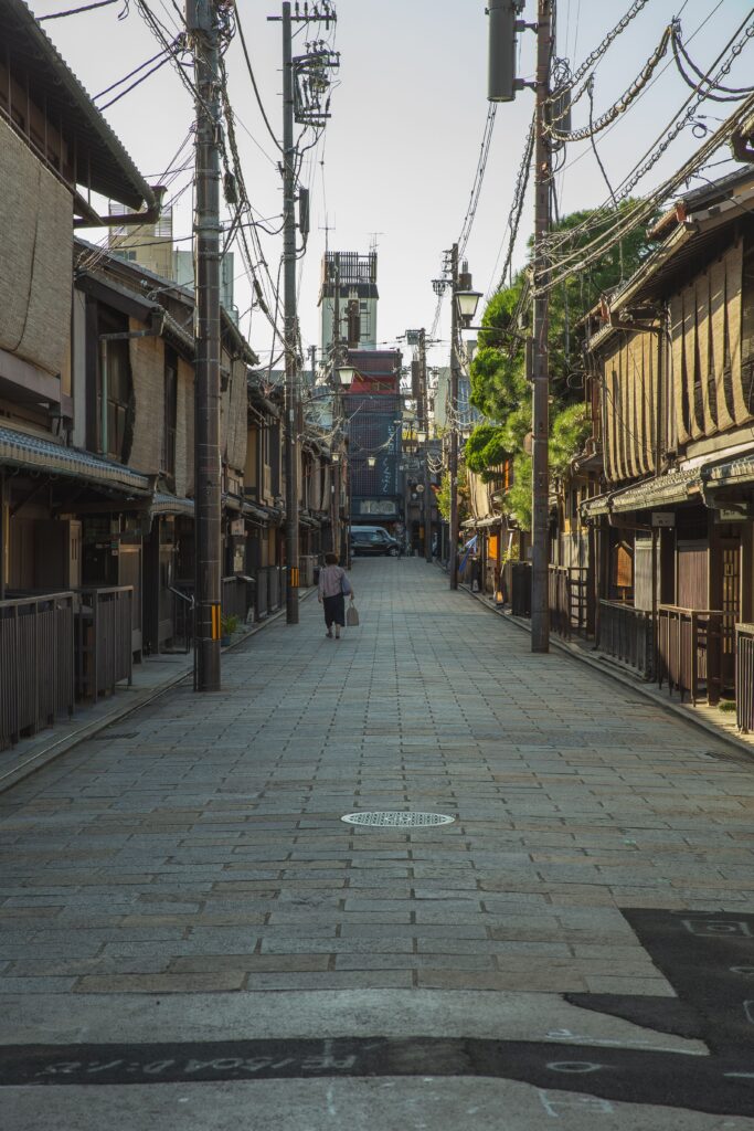 A person walking through quiet Gion streets in the morning