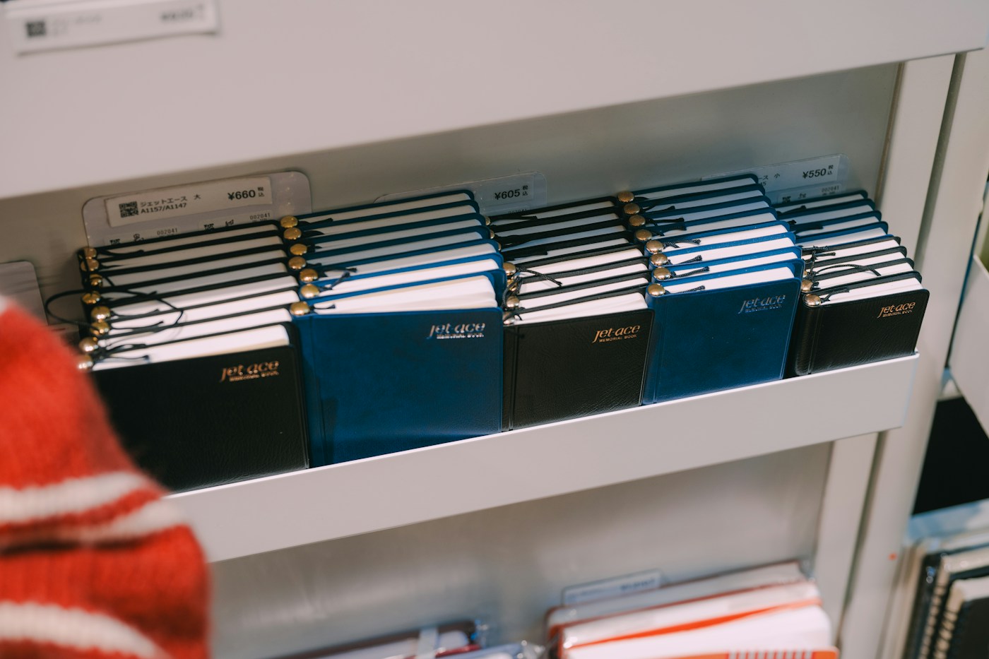 Blue and black notebooks on a shelf at Ginza Itoya