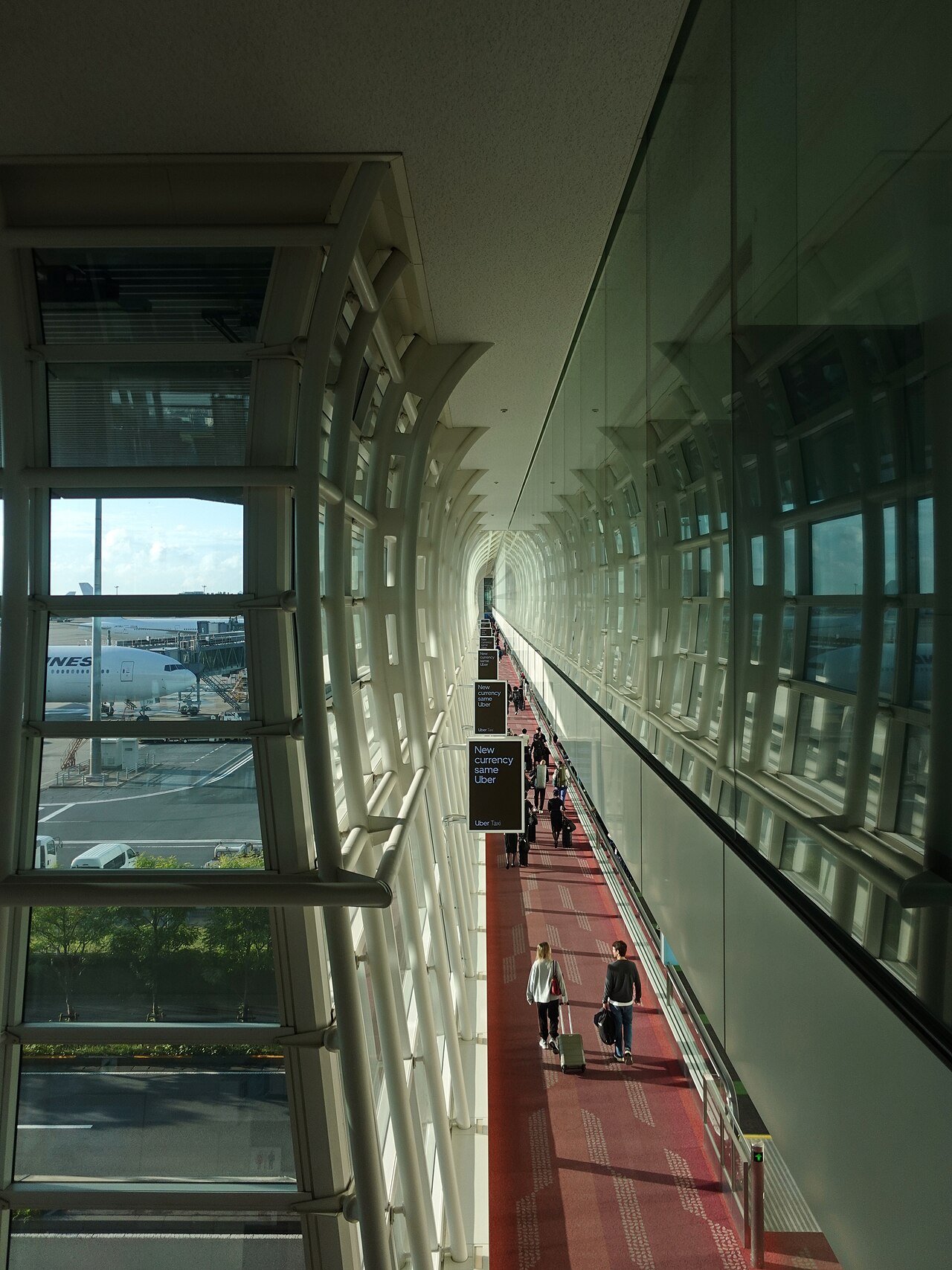 Travellers pulling suitcases through the arrivals passage at Haneda Airport Terminal 3