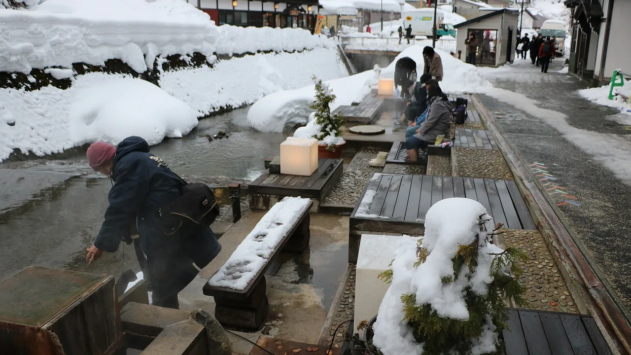Travellers walking through snowy Ginzan Onsen