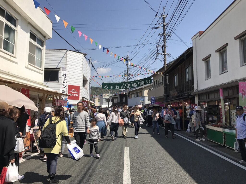 Visitors walking past pottery shops at the Arita pottery fair