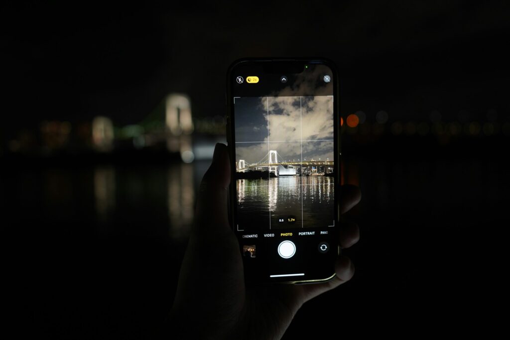 Hands photographing Tokyo at night with a smartphone