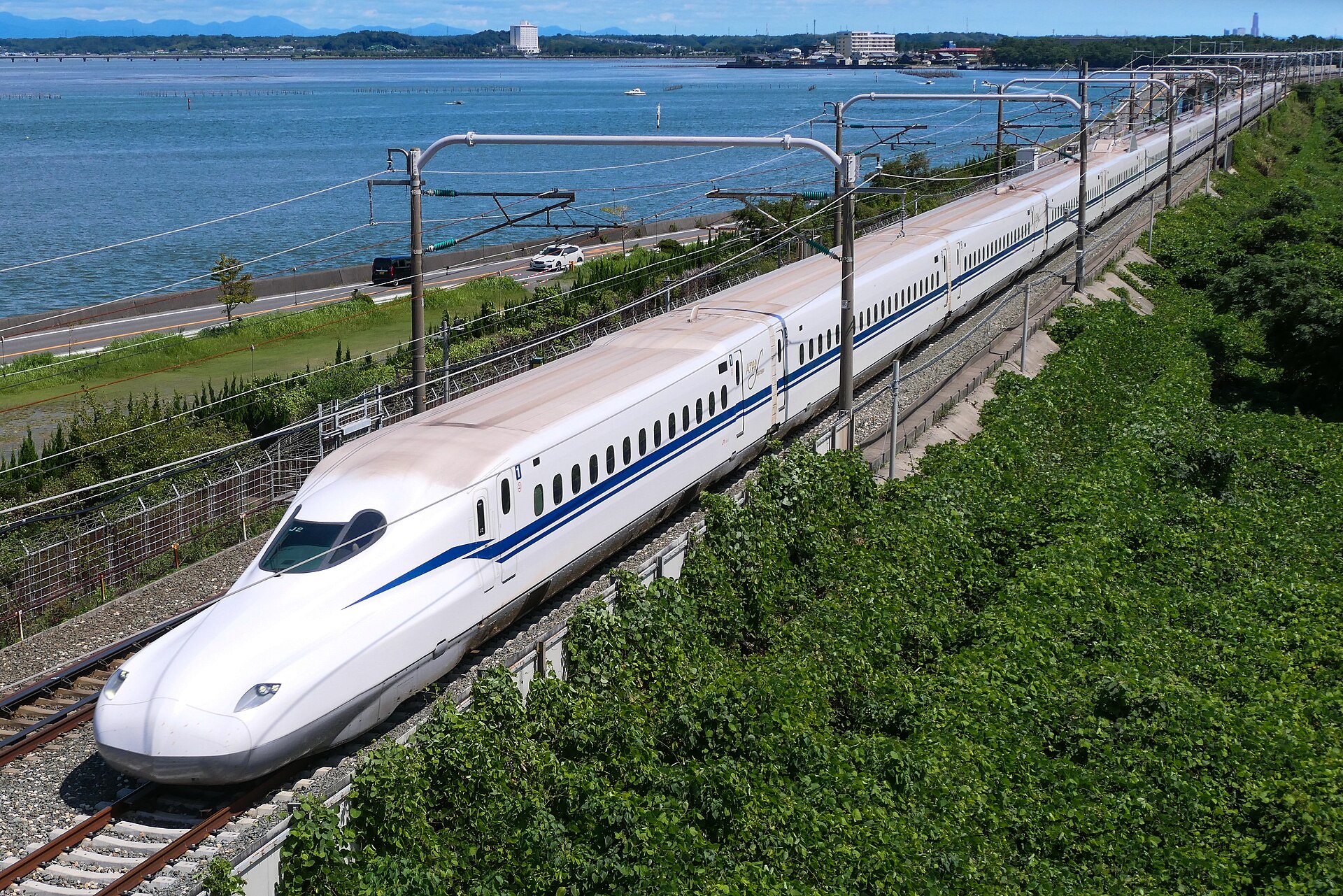 An N700S Shinkansen running beside the sea