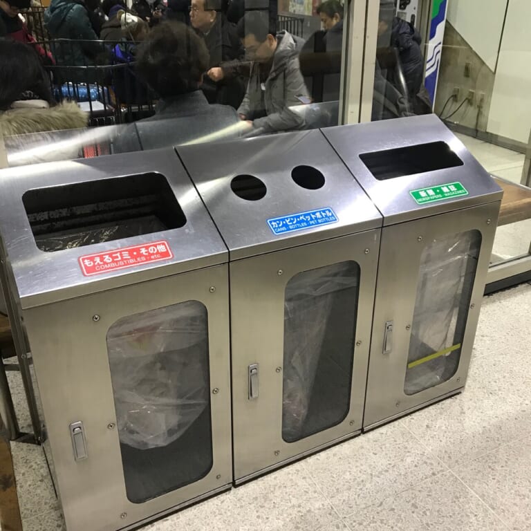 Bins for burnable waste, drink containers, newspapers and magazines inside a Japanese facility