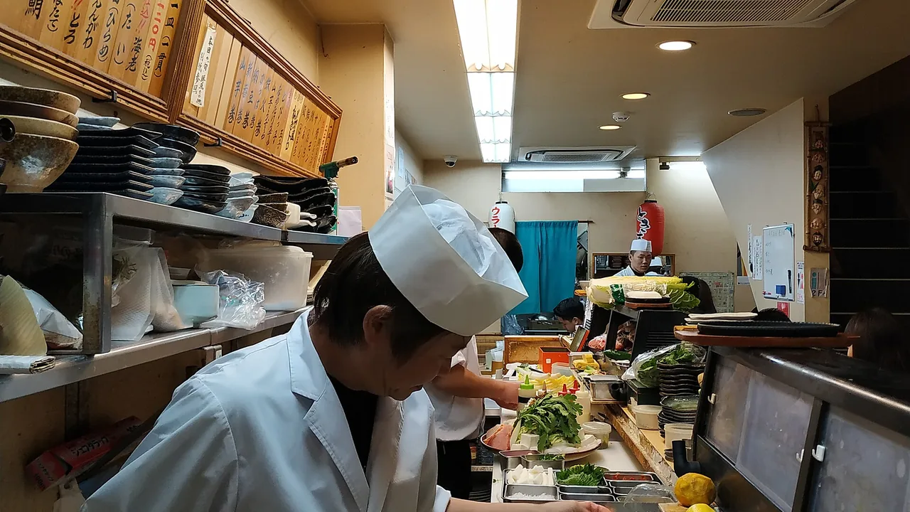 A sushi chef working behind a restaurant counter