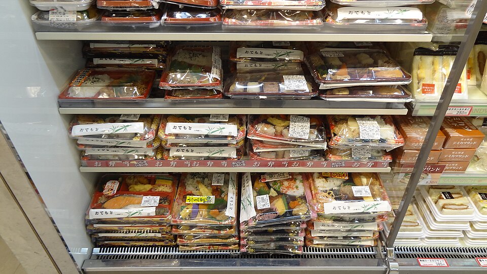 Bento boxes and prepared meals in a refrigerated convenience-store display in Japan