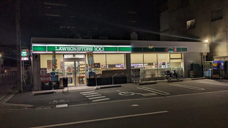 A Lawson Store 100 convenience store illuminated at night