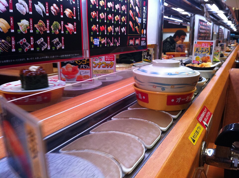 Plates travelling along a conveyor-belt sushi counter