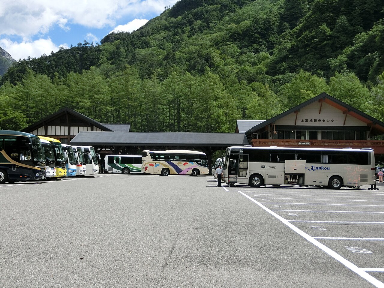 Buses at Kamikochi Bus Terminal beneath the surrounding mountains
