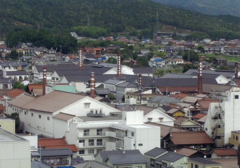 White-walled brewery buildings and red brick chimneys in Saijo’s sake district