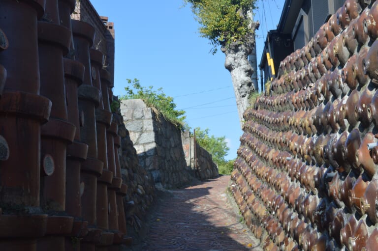 Dokanzaka in Tokoname, with a pottery-paved slope between walls of pipes and shochu bottles