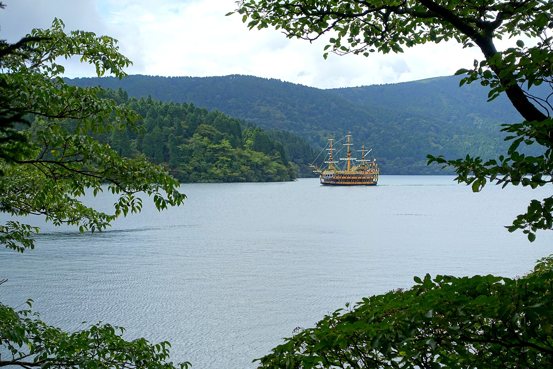 A Lake Ashi pirate ship seen through lakeside foliage