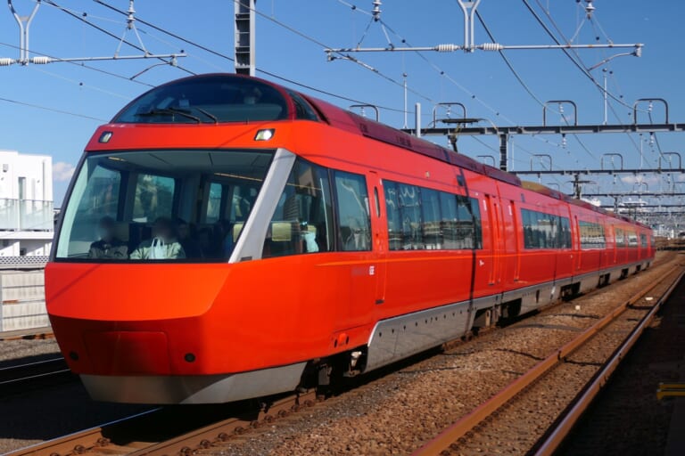 A red Odakyu Romancecar GSE on the railway