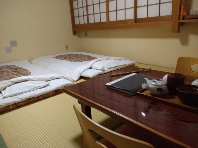 Futon and a low table in a tatami room at a Japanese inn