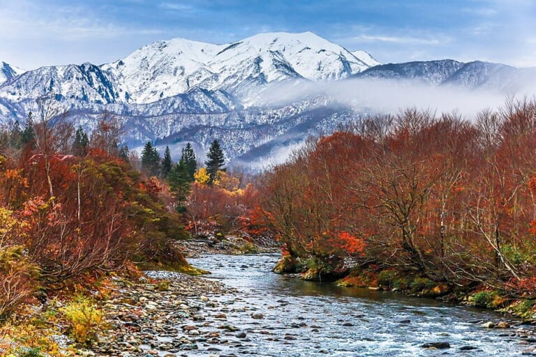 Autumn foliage and snowy mountains at Ginzandaira in Uonuma, Niigata