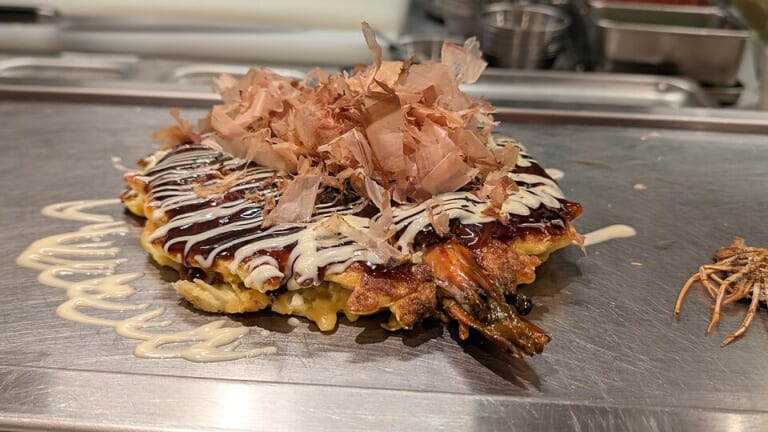 An okonomiyaki served on a hot plate in Osaka
