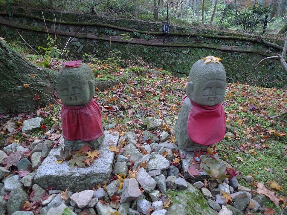 Small stone Jizo figures among fallen leaves in a Sanzen-in garden