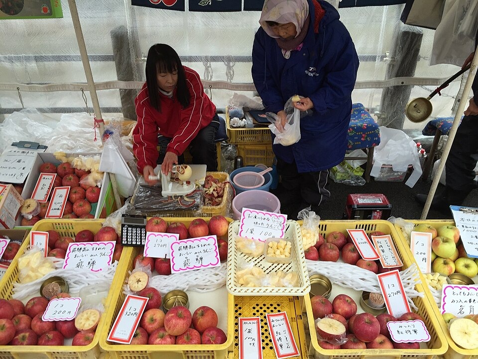 A vendor and shopper at Takayama’s Miyagawa Morning Market
