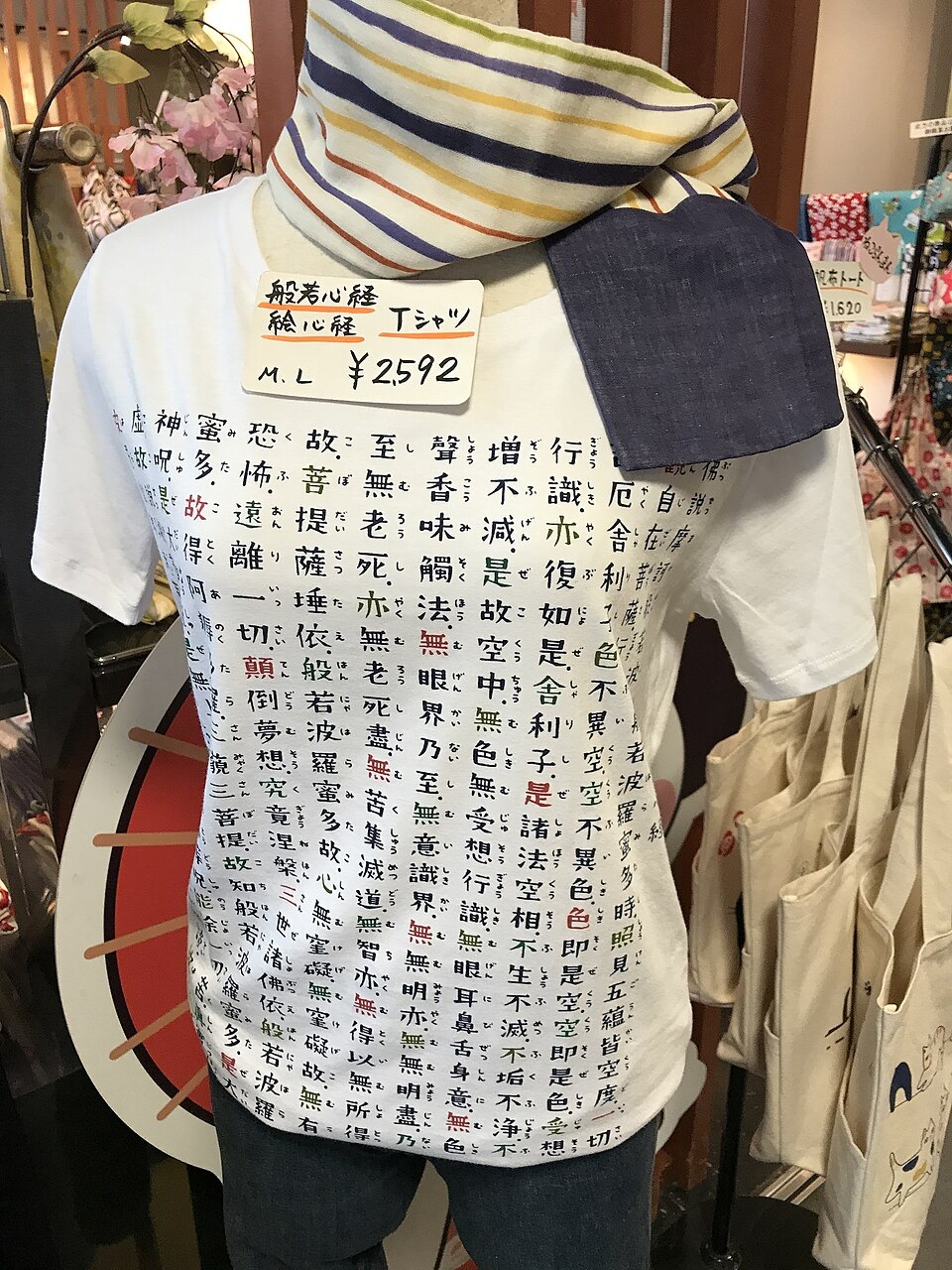A tenugui printed with the Heart Sutra hanging in a shop display