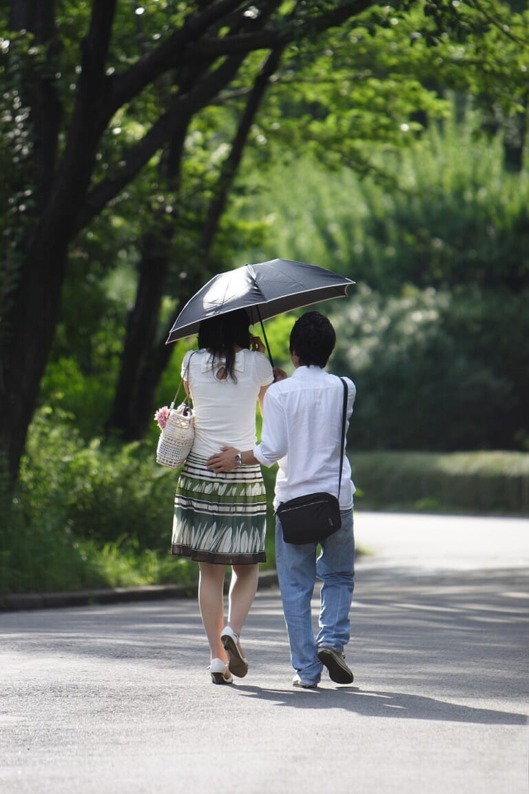People walking beneath a parasol in the East Gardens of Tokyo Imperial Palace