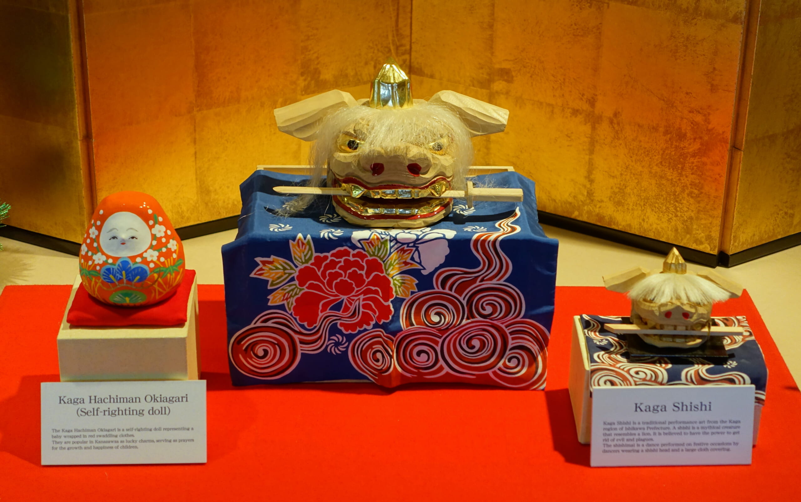 Kaga lion heads and Hachiman roly-poly dolls on display