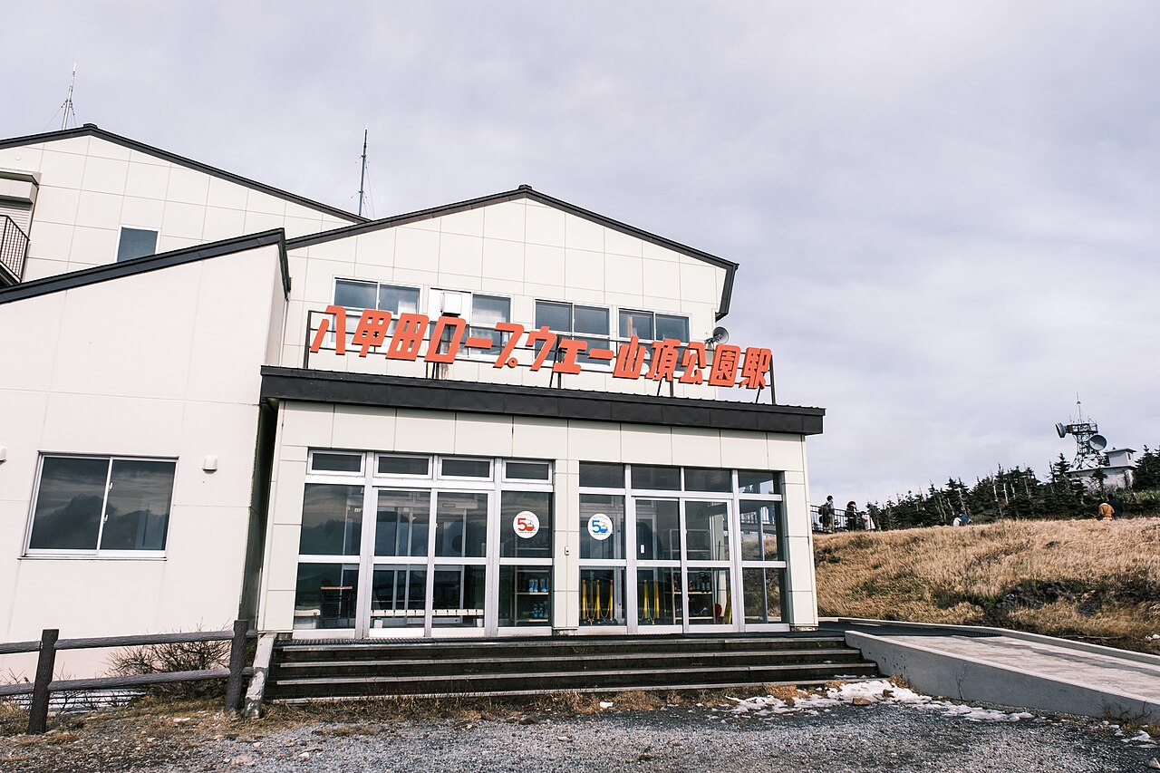 Entrance to Hakkoda Ropeway’s Sancho-koen Station beside open grassland