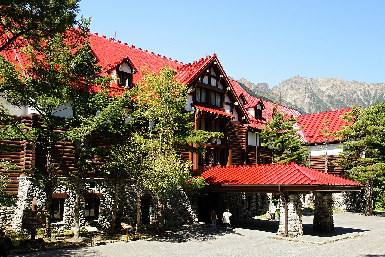 The red roofs and timber exterior of the Kamikochi Imperial Hotel below the mountains