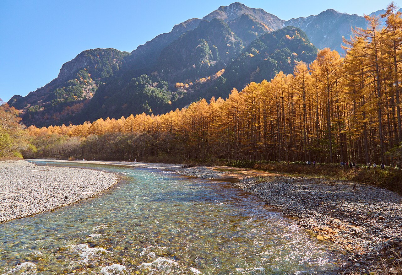 The Azusa River beneath autumn larches and mountain slopes in Kamikochi