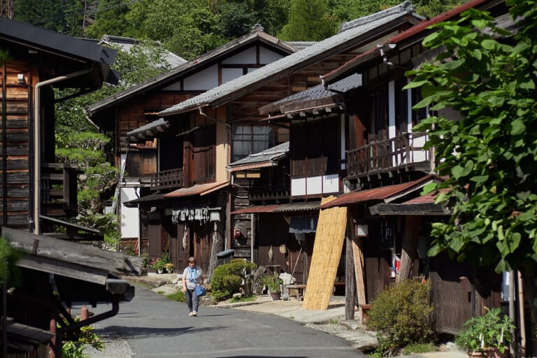 A pedestrian on the historic street lined with wooden houses in Tsumago