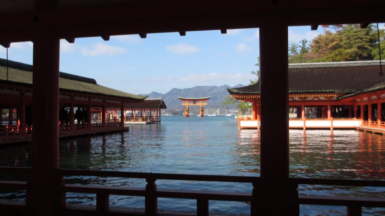Itsukushima Shrine corridors surrounded by water with the Great Torii in the distance