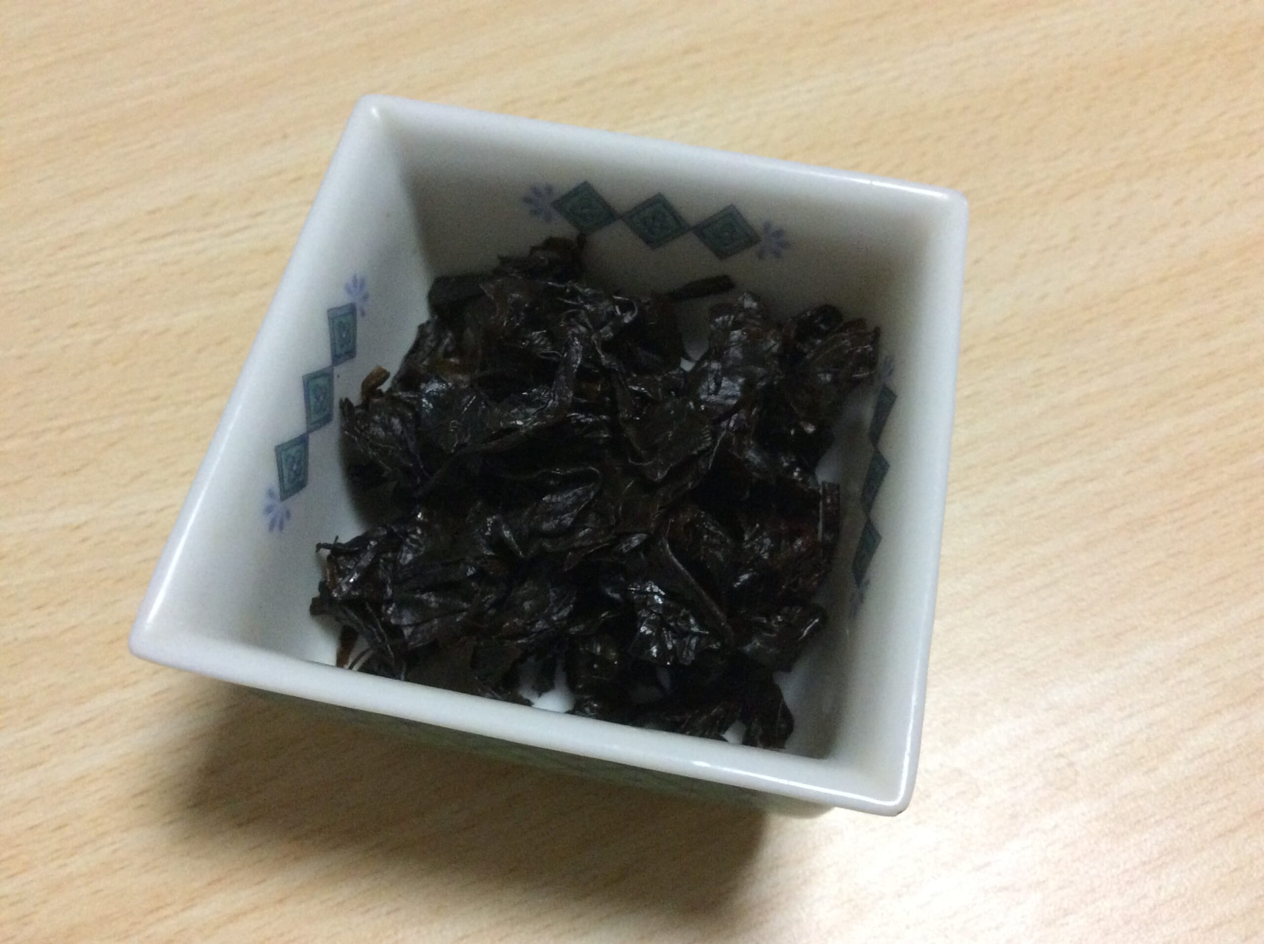 An illustrative example of chilli-leaf tsukudani served in a small bowl